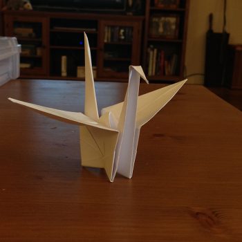 Origami crane sitting on a wooden table